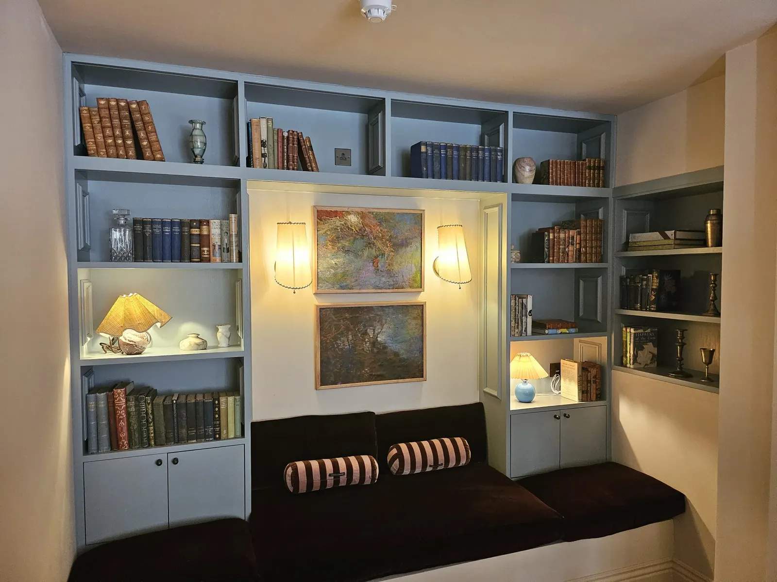 Built-in bookshelves painted pale blue around a window seat