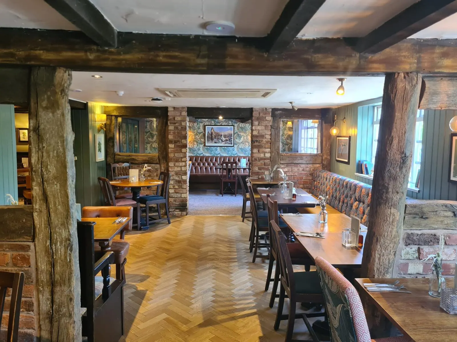Pub interior with timber beams, exposed brick and parquet floor