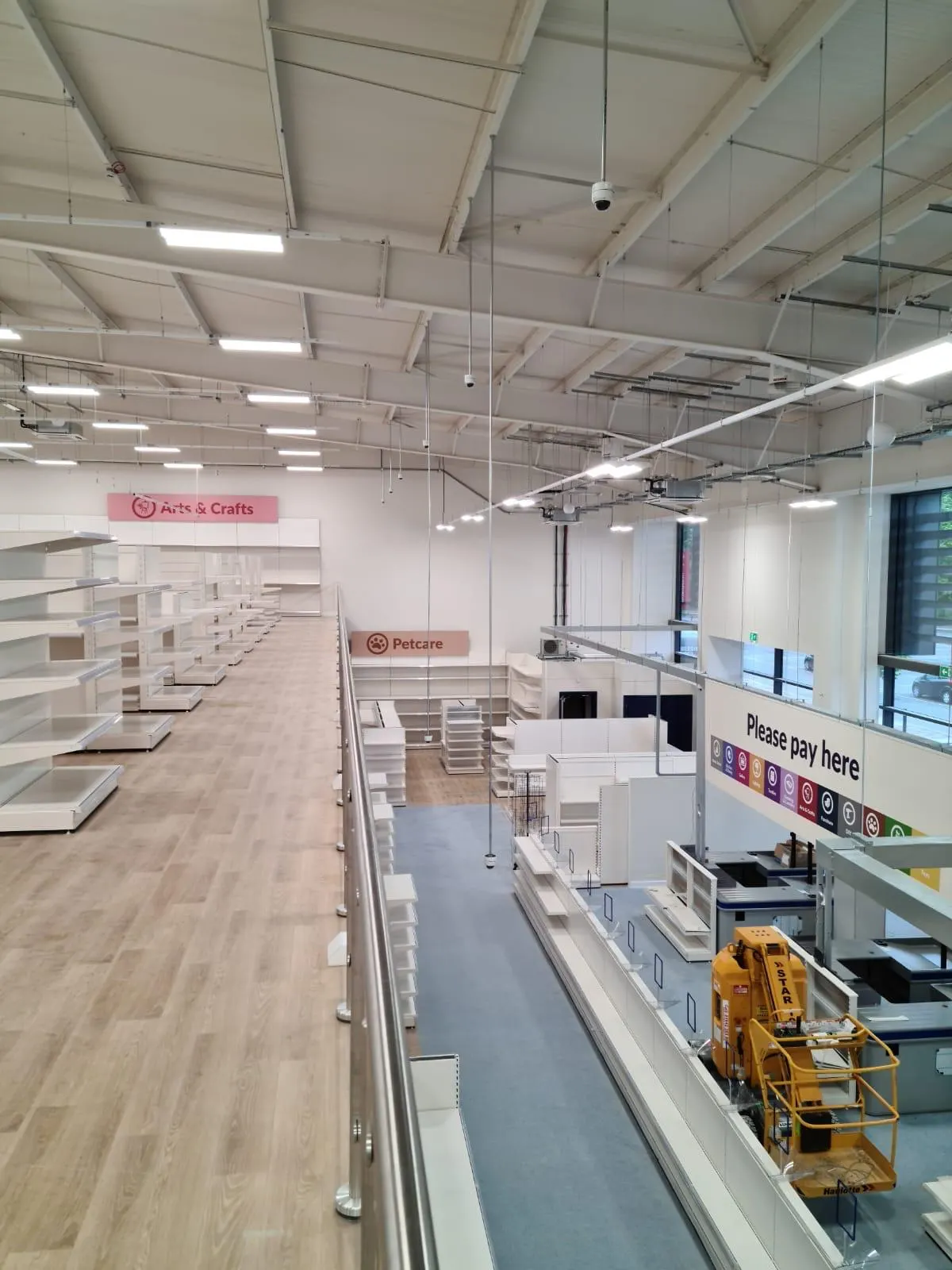 Retail store mezzanine with white shelving during a store refit