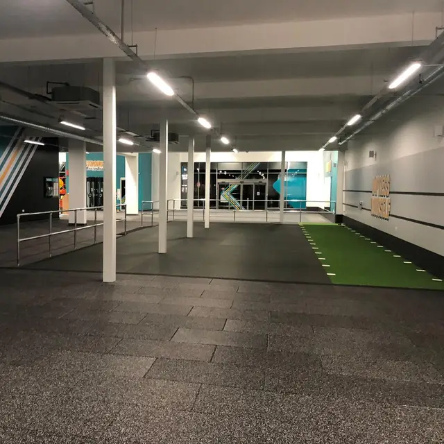 Gym training floor with painted columns and teal feature wall stripes
