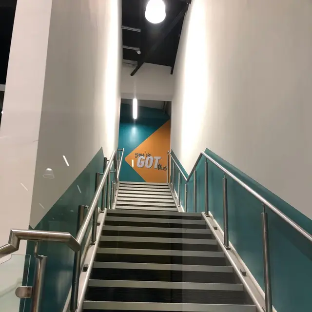 Staircase with teal and white painted walls in a gym
