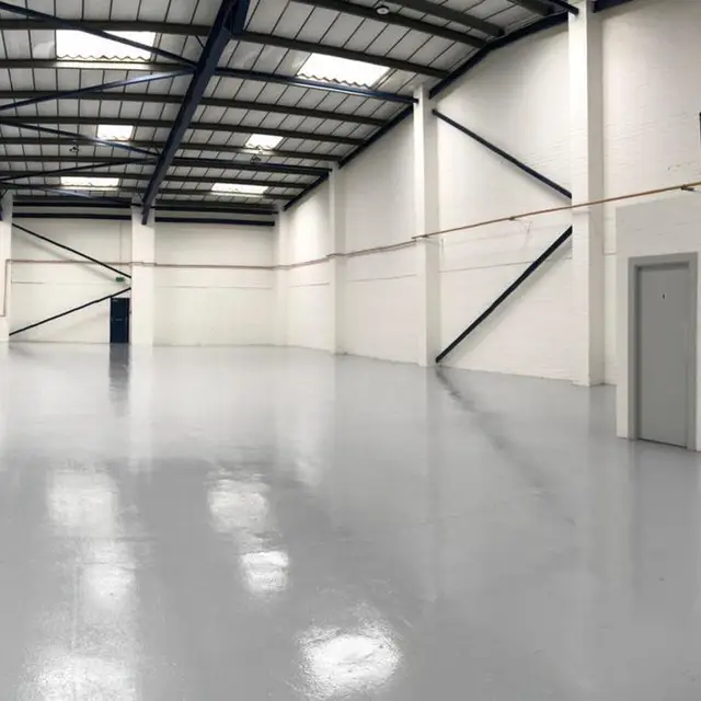 Empty industrial unit with white painted walls and grey floor coating