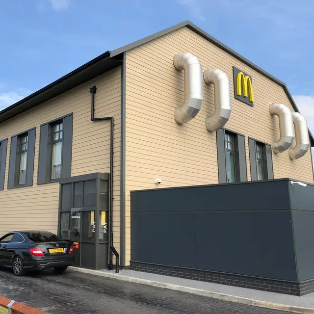 Drive-thru restaurant exterior with painted cladding and grey window frames
