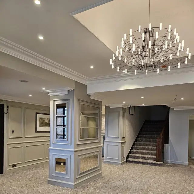 Reception with painted panelled column, staircase and chandelier