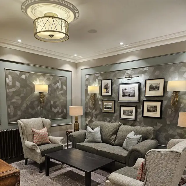 Sitting room with grey panelling and patterned feature wallpaper