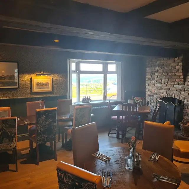 Pub dining room with dark beams and an exposed brick fireplace