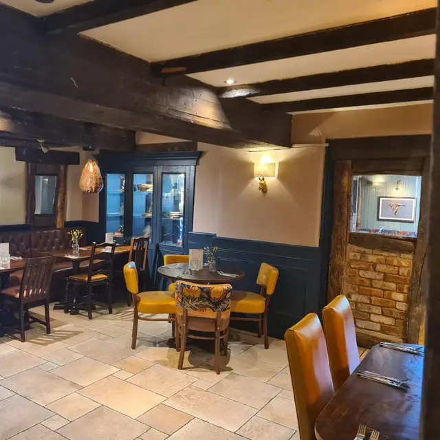 Pub dining area with navy panelling and cream walls under timber beams
