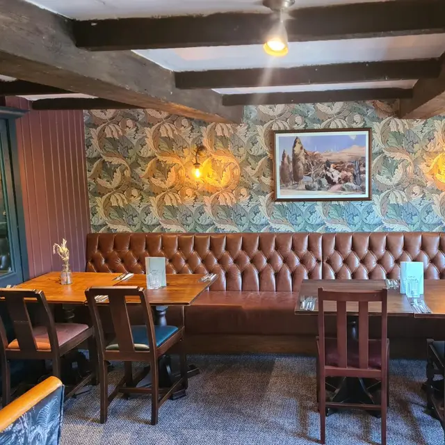 Pub dining room with botanical feature wallpaper and leather banquette