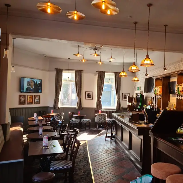 Traditional pub interior with dark timber bar and painted walls