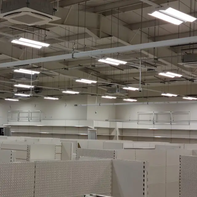 Retail unit ready for fit-out with white shelving and painted ceiling