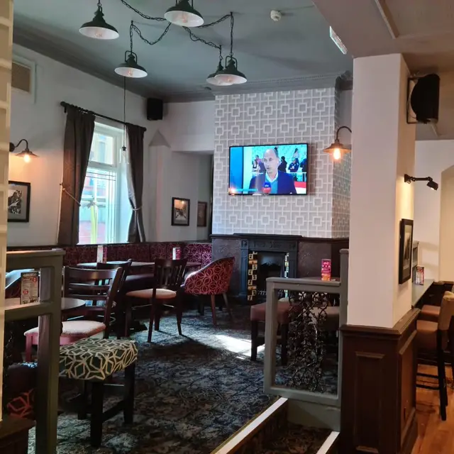 Pub seating area with white painted pillar and geometric feature wall