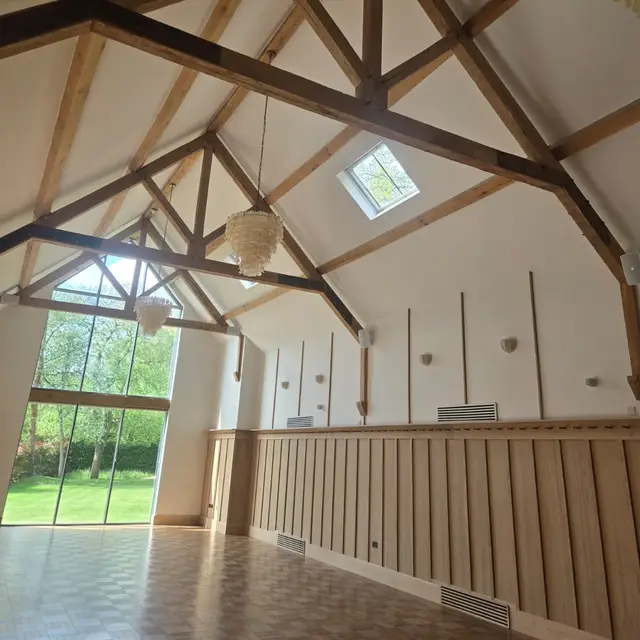 Vaulted room with oak roof trusses and timber panelling