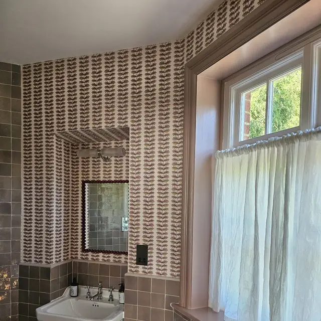 Bathroom with patterned wallpaper and brown wall tiles
