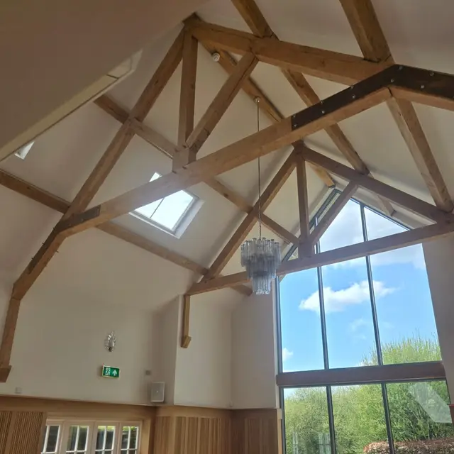 Vaulted wedding venue with oak trusses and full-height glazing