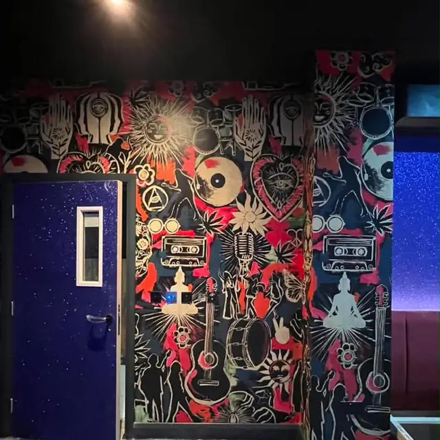Music-themed mural wallpaper beside a painted door